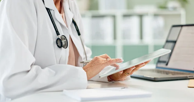 Hands, doctor and click on tablet in hospital for telehealth, contact or notification on application. Medic, digital touchscreen and s
